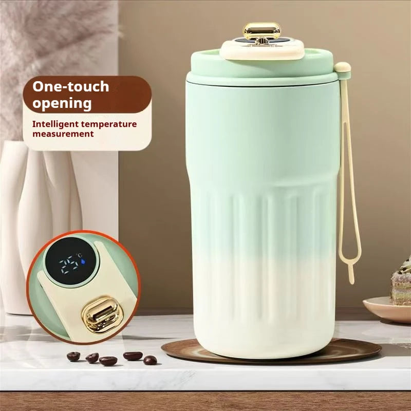 Light blue and white insulated mug with digital thermometer on a marble surface.