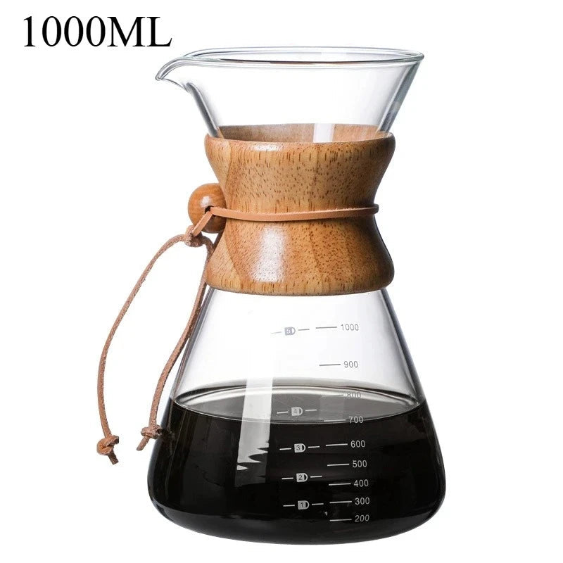 Clear glass coffee maker with wooden lid and black liquid inside, on a white background.