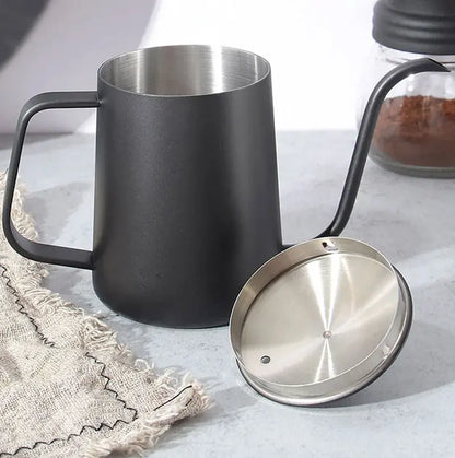 Matte black pour-over coffee mug with a stainless steel interior and spout, shown alongside its stainless steel lid on a light gray surface.