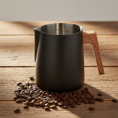 A matte black stainless steel milk pitcher with a light brown wooden handle