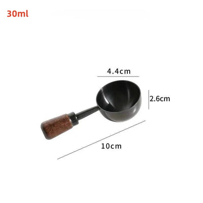 A small black metal scoop or ladle with a brown wooden handle, shown on a plain white background.