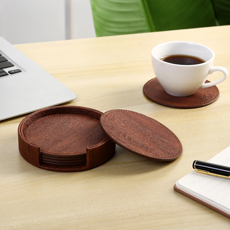 Set of brown wooden coasters on a table with a cup of coffee and laptop.