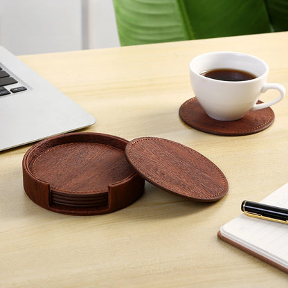 Set of brown wooden coasters on a table with a cup of coffee and laptop.