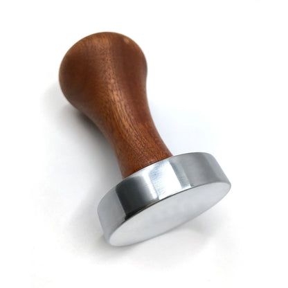 Coffee tamp with wooden handle and metal base on a white background