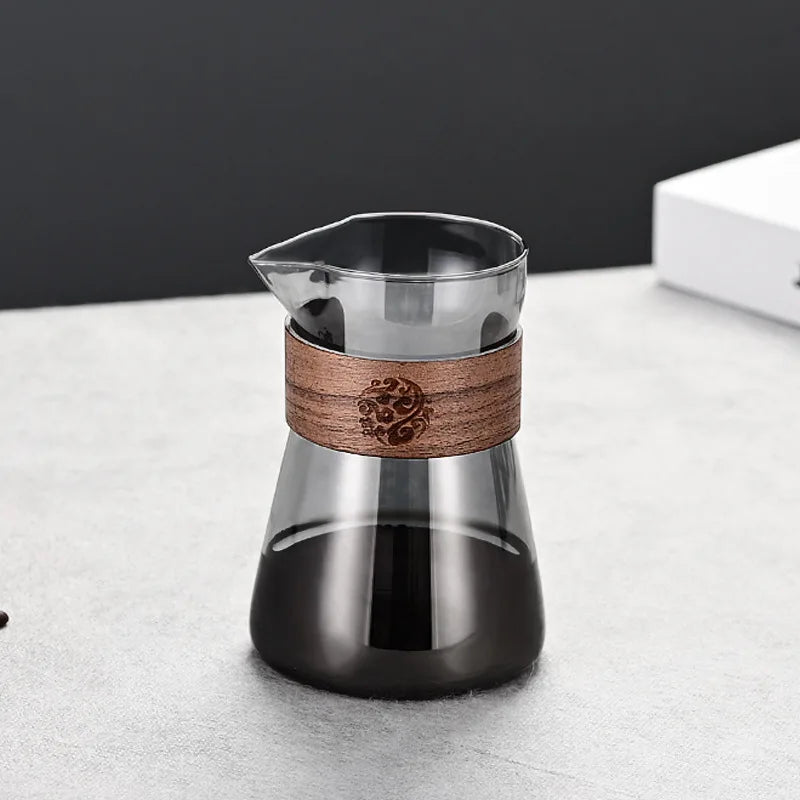 Glass coffee maker with wooden band on a light surface