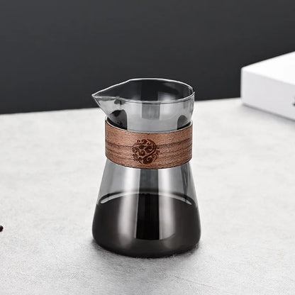 Glass coffee maker with wooden band on a light surface
