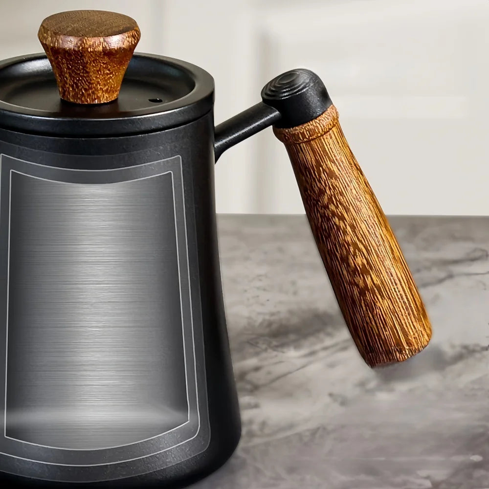 Handheld coffee grinder with wooden handle and top on a marble surface