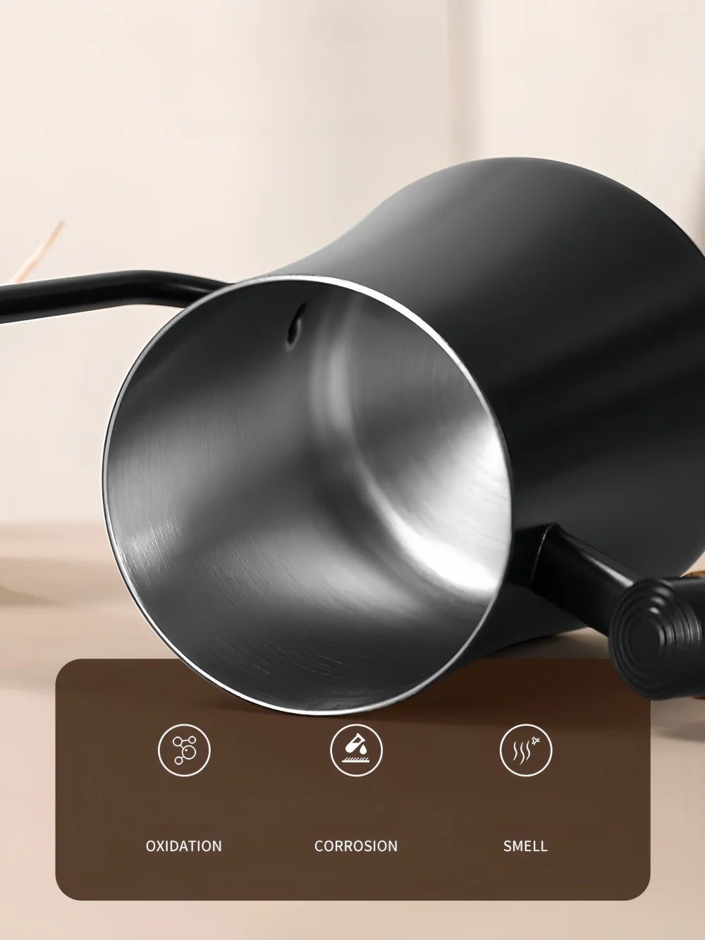 Close-up of a matte black metal pitcher or kettle with a brushed silver interior, shown against a warm beige background with a brown feature panel at the bottom highlighting oxidation, corrosion, and smell.