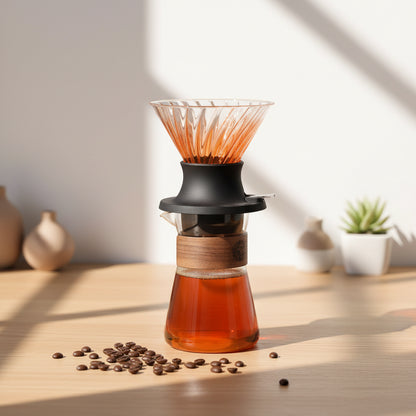 Coffee brewing device with glass container and wooden base on a wooden surface.