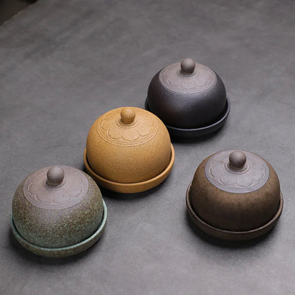 Four ceramic containers with lids on a gray surface