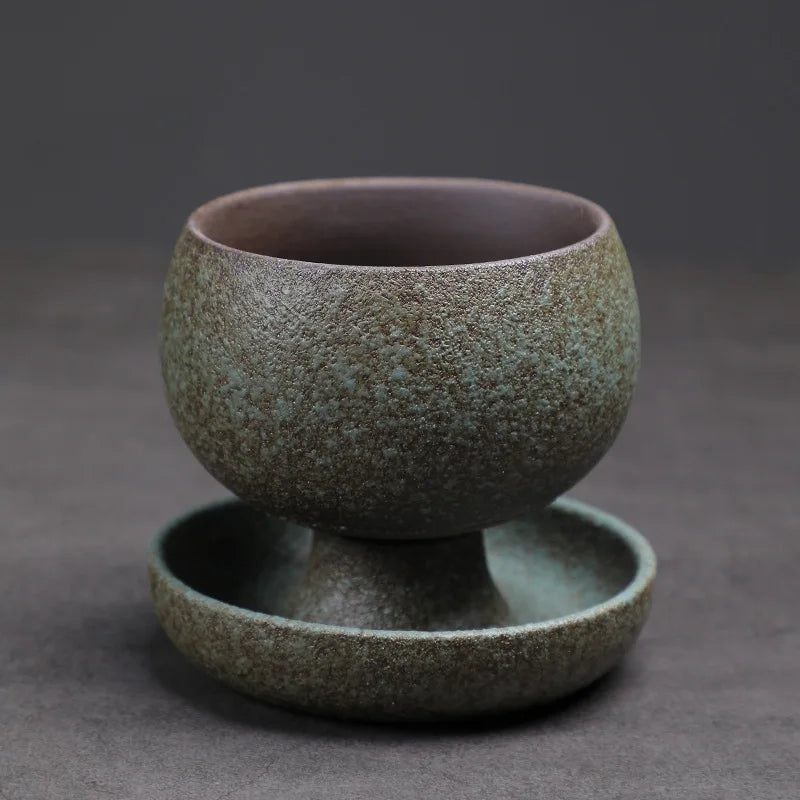 Green ceramic cup and saucer set on a dark gray background