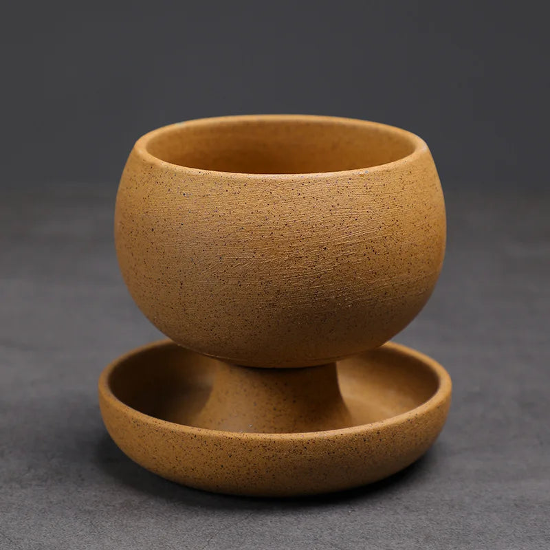 Brown ceramic cup with saucer on a dark gray background