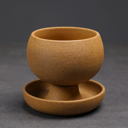 Brown ceramic cup with saucer on a dark gray background