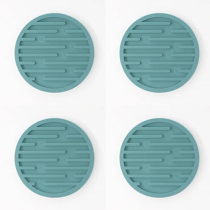 Four teal silicone trivets on a white background