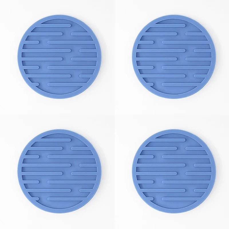 Four blue silicone trivets with textured surface on a white background
