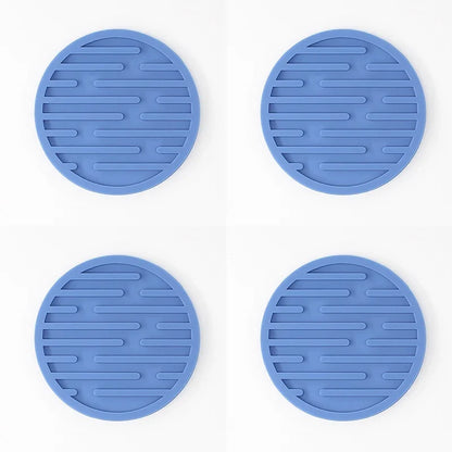 Four blue silicone trivets with textured surface on a white background