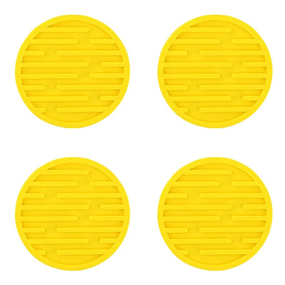 Four yellow circular silicone mats with a textured surface on a white background