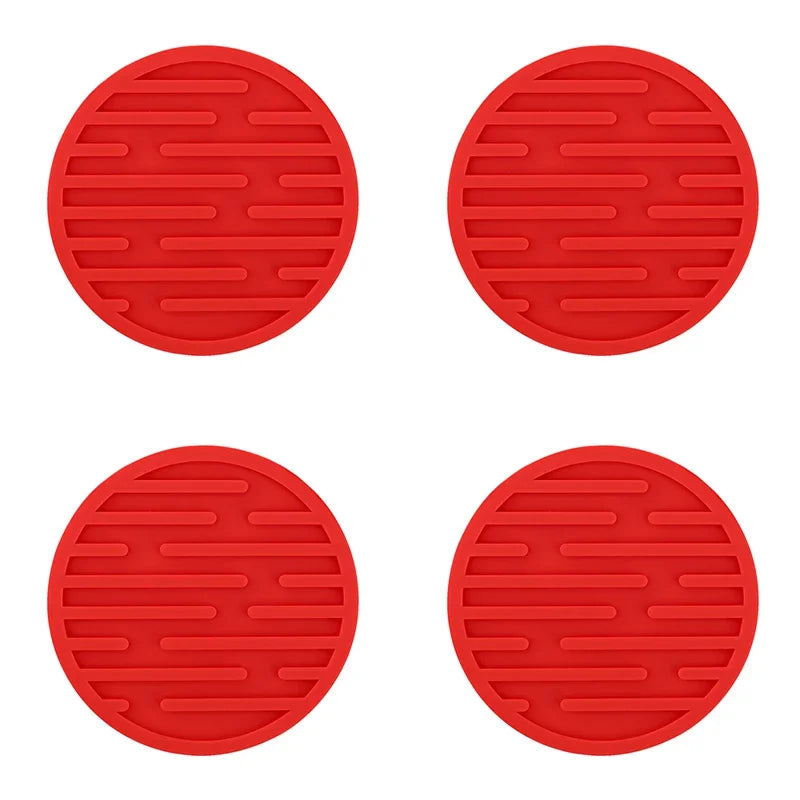 Four red silicone coasters on a white background