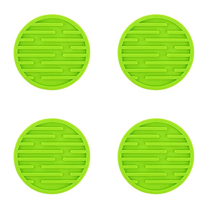 Four green silicone trivets with textured surface on a white background