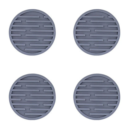 Four gray silicone trivets with textured surface on a white background