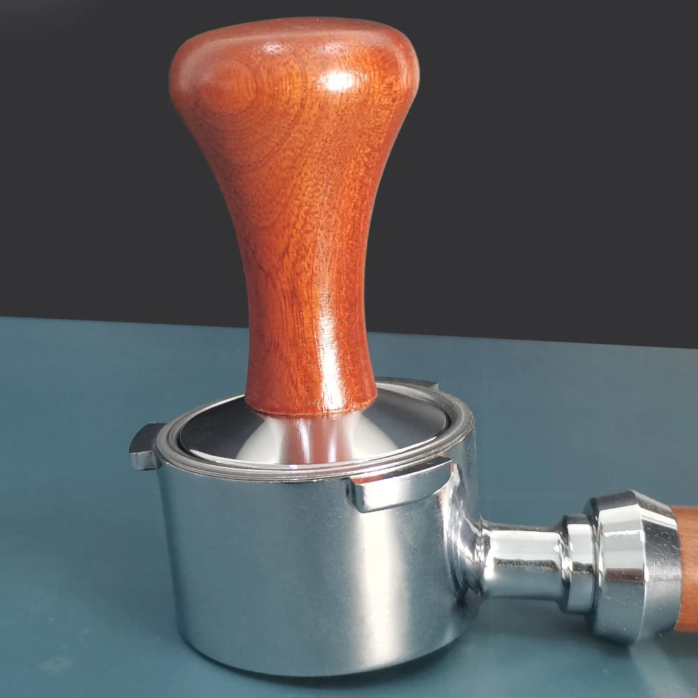 Coffee tamp with wooden handle on a blue surface