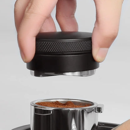Person using a black coffee tamper