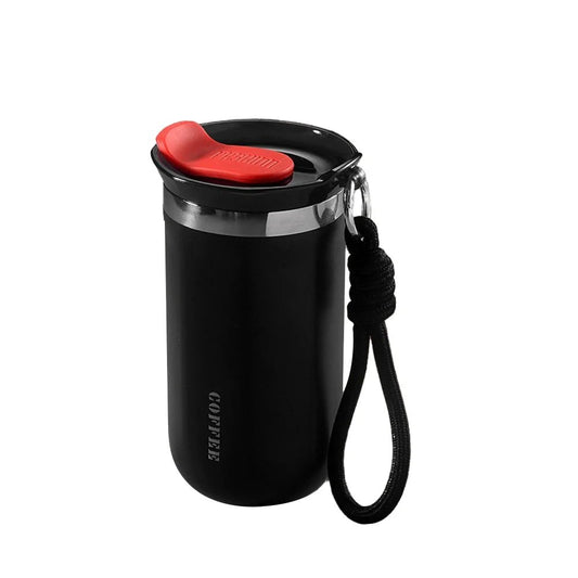 Black coffee tumbler with a red lid and black strap on a white background