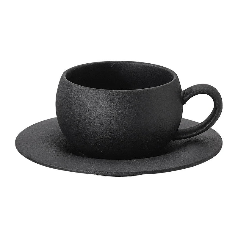 Black ceramic cup and saucer set on a white background