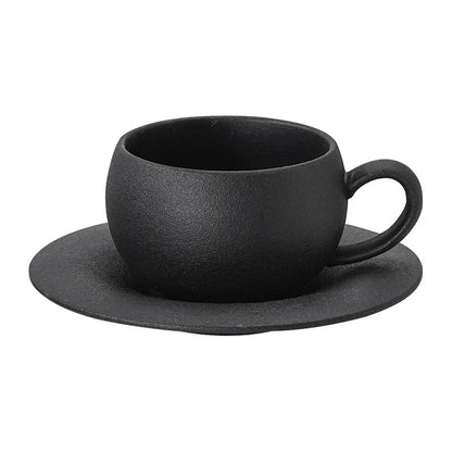 Black ceramic cup and saucer set on a white background