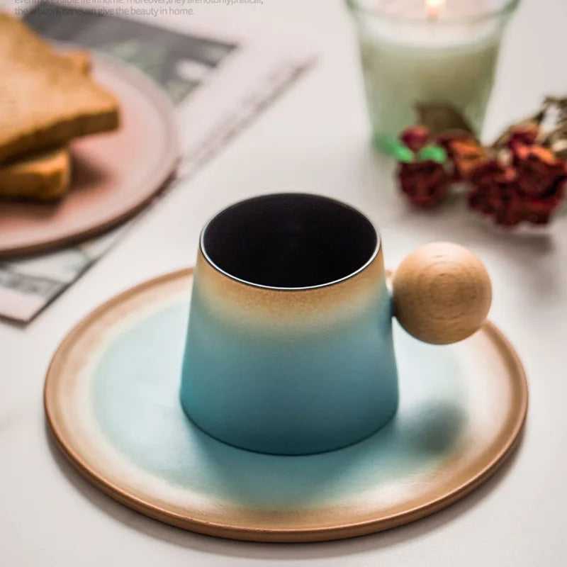 Blue ceramic mug with wooden handle on a matching coaster, with toast and candle in the background.