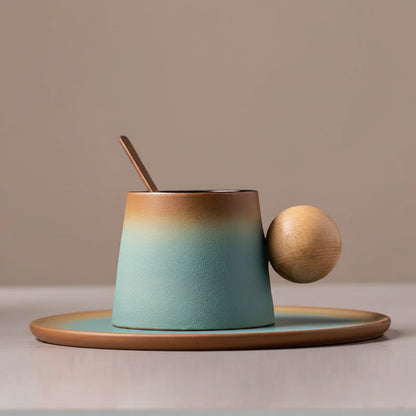 Teal ceramic cup with wooden handle and spoon on a matching saucer against a beige background