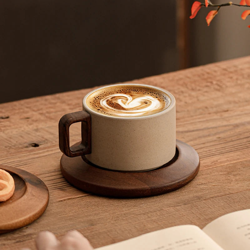Cappuccino in a ceramic cup with a wooden handle on a wooden table.