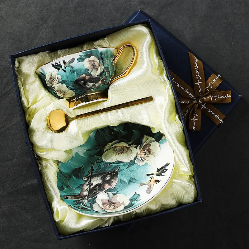 Ceramic teacup and saucer with floral and bird design in a decorative box.