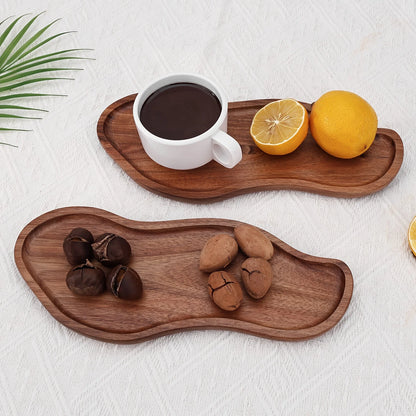 Wooden trays with a cup of coffee, lemons, and chestnuts on a white surface.