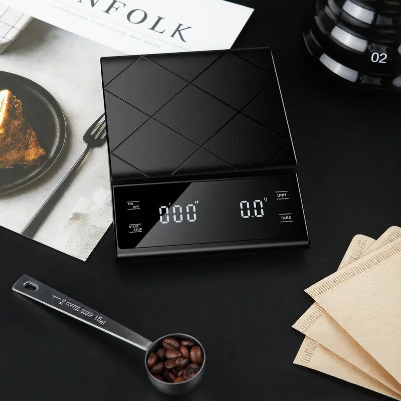 Black digital kitchen scale on a table with coffee beans and coffee filters.
