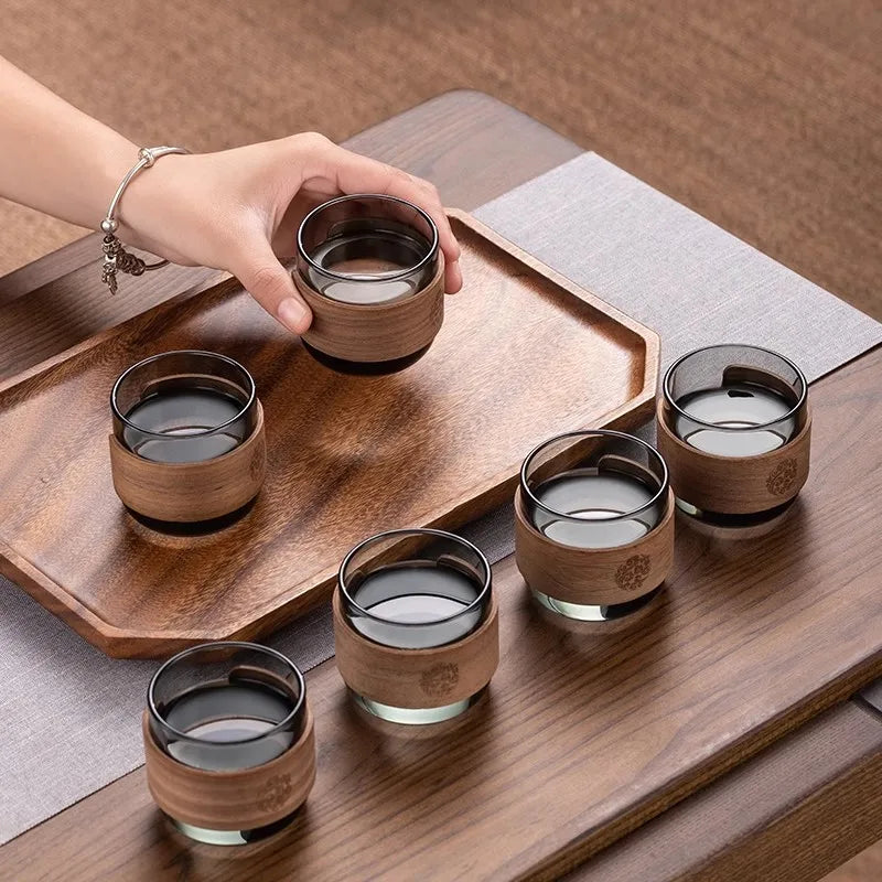 Set of six wooden cups with a wooden tray on a wooden surface