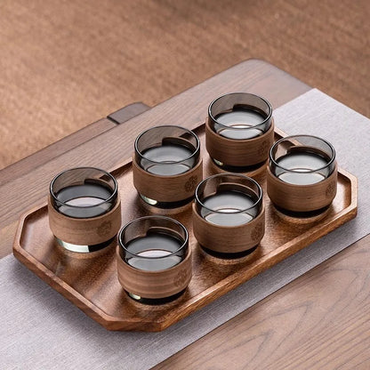 Set of six wooden cups with a wooden tray on a wooden surface