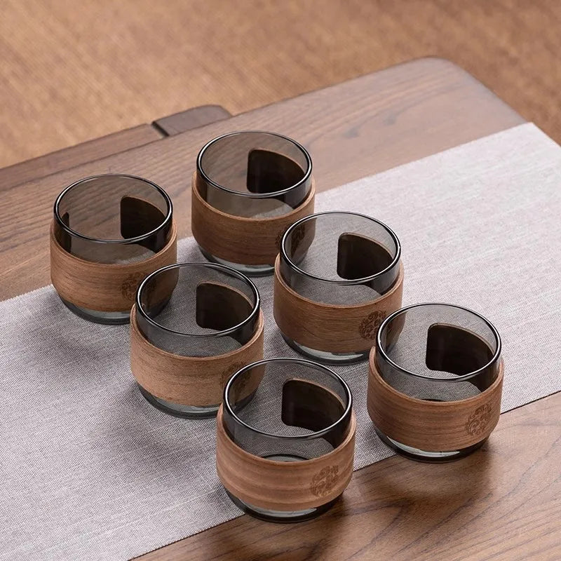 Set of six wooden cups with a wooden tray on a wooden surface