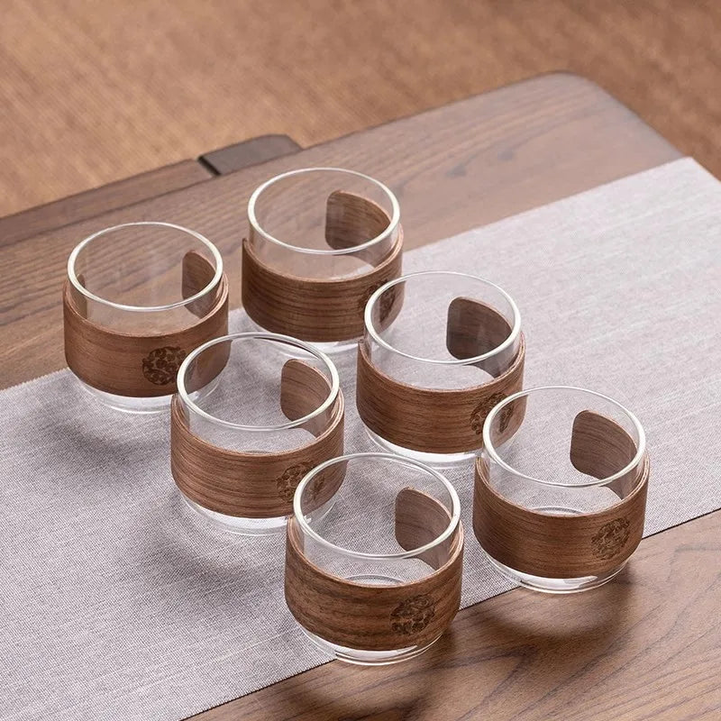 Set of six wooden cups with a wooden tray on a wooden surface