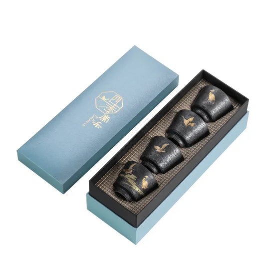 Box of black chocolate with gold accents in a light blue box on a white background