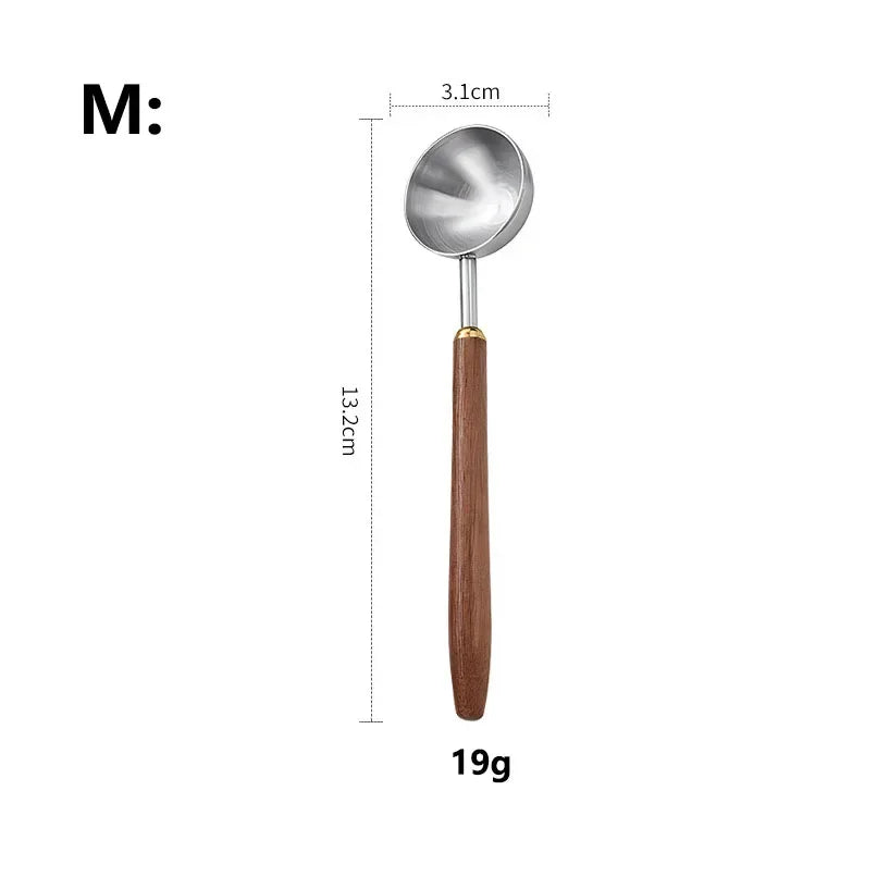 A metal ladle with a wooden handle and a small gold-toned ferrule, shown on a white background with dimension labels indicating 13.2 cm length, 3.