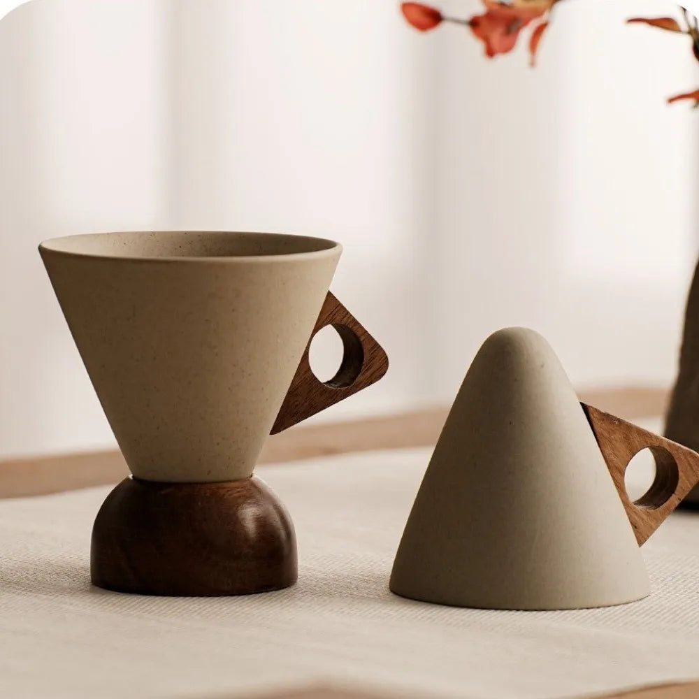 Two ceramic and wooden tea infusers on a light surface with a blurred background