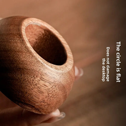 Wooden bowl held by a hand with a blurred background