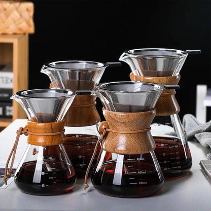 Set of wooden and glass coffee brewing devices on a table.
