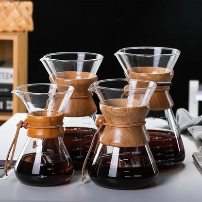 Set of wooden and glass coffee brewing devices on a table.