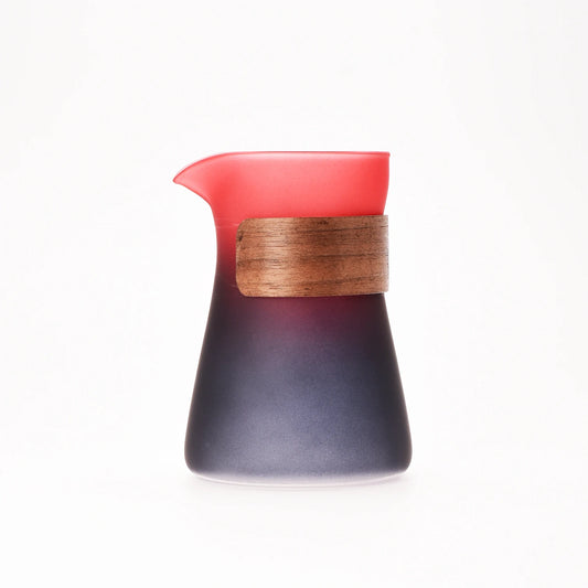 Ceramic pitcher with wooden handle on a white background