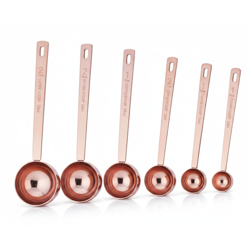 Set of five stainless steel measuring spoons with measurements on a white background
