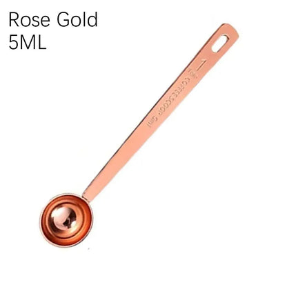 Rose gold measuring spoon with '5ML' marking on a white background