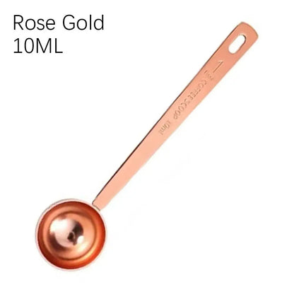 Rose gold measuring spoon with '10ML' marking on a white background