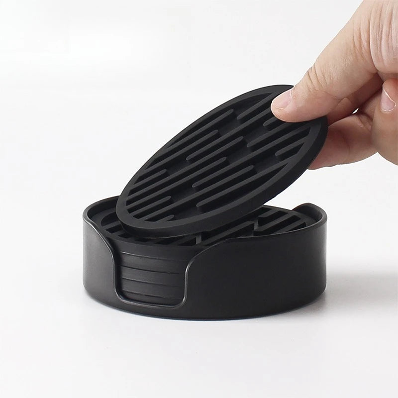 Black silicone mat with textured surface held by a hand on a white background